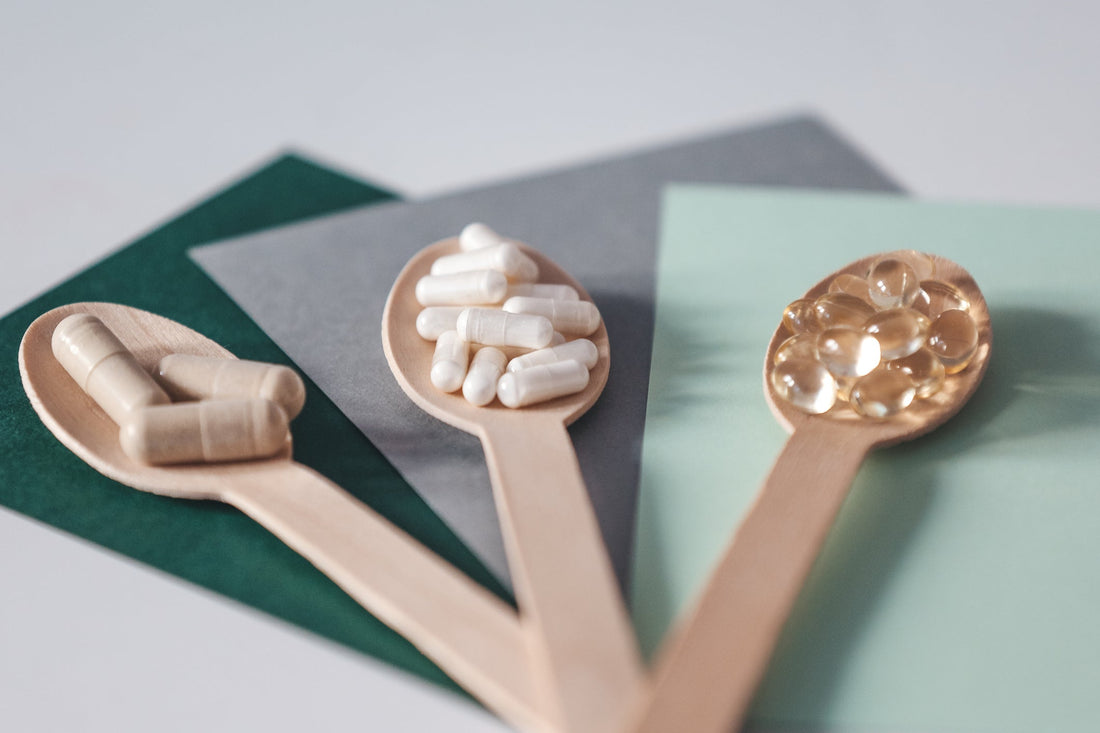 Different vitamin supplements on wooden spoons