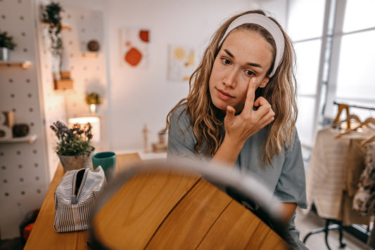 Woman applying face cream under her eyes