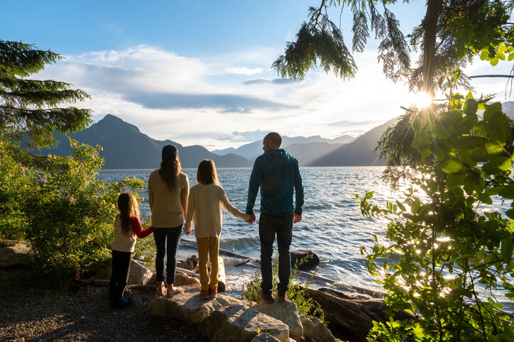 Family holding hands on a rocky Canadian beach
