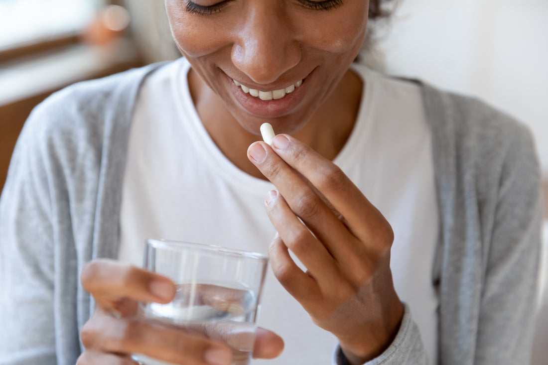 Close-up of a happy young woman taking vitamins 