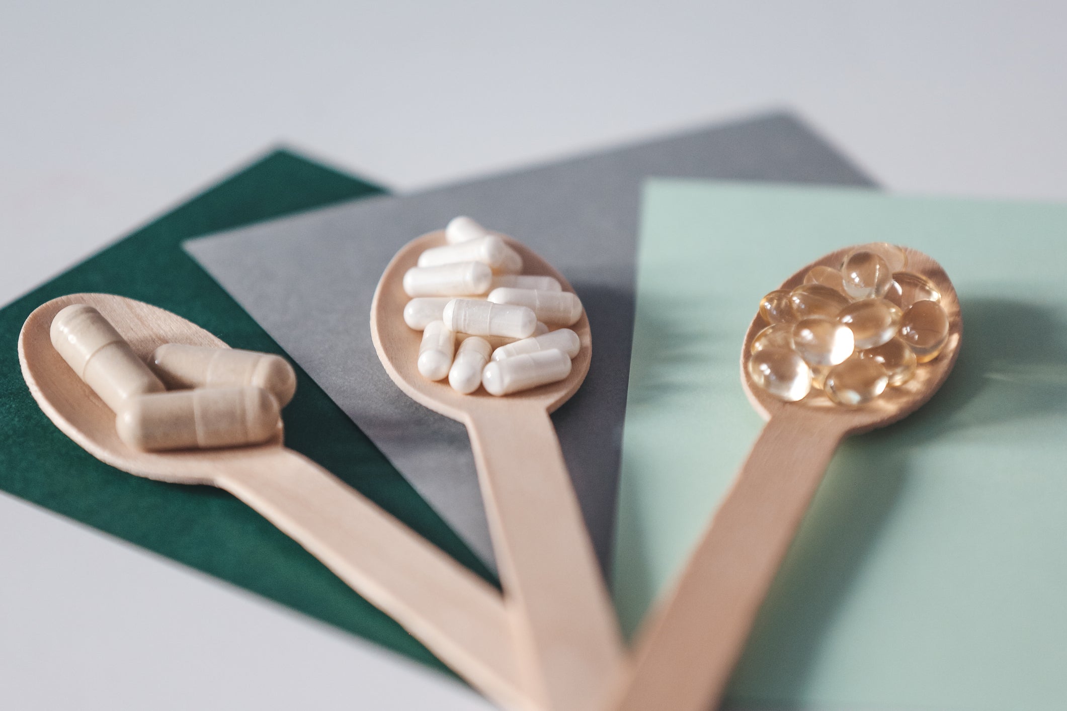 Different vitamin supplements on wooden spoons 