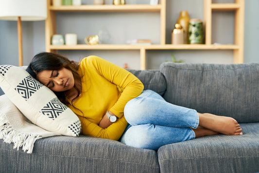 Shot of a young woman experiencing stomach cramps at home. 
